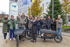 Stellvertretende Landrätin und Bürgermeister stehen mit Lastenrädern an einer Mobilitätsstation.